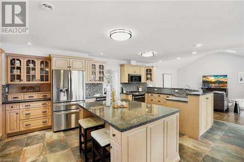 Gourmet kitchen featuring granite countertops, high-end stainless-steel appliances, and a spacious center island breakfast bar—perfect for family gatherings and elegant dining. - 551 Darby Road, Welland, ON - Indoor Photo Showing Kitchen