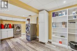 Bright laundry room with built in cabinets and shelving for more storage - 