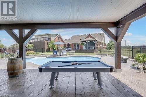 Backyard Paradise with a heated saltwater pool, landscaped gardens, and a cozy firepit area, this outdoor space is ideal for relaxing and entertaining. - 551 Darby Road, Welland, ON - Outdoor With In Ground Pool With Deck Patio Veranda With Backyard