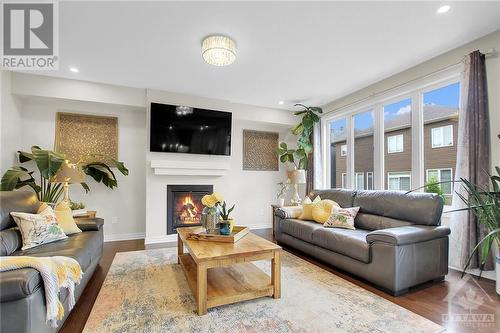 Huge family room with cozy gas fireplace and wall of windows - 915 Guinness Crescent, Ottawa, ON - Indoor Photo Showing Living Room With Fireplace