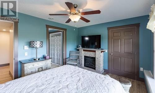 14 Church Road, Pilley'S Island, NL - Indoor Photo Showing Bedroom With Fireplace