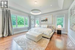 Primary bedroom retreat flooded with natural light. Enjoy music on your integrated speaker system and features two walk-in closets. - 