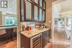 Convenient butler's pantry complete with a wine fridge and wet bar, ideal for entertaining friends and family. - 