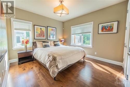 Both secondary rooms boast bright windows, hardwood flooring, and integrated speakers with separate controls. - 6163 Pebblewoods Drive, Ottawa, ON - Indoor Photo Showing Bedroom