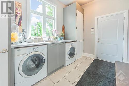 Main floor laundry room with inside garage access & plenty of storage. - 6163 Pebblewoods Drive, Ottawa, ON - Indoor Photo Showing Laundry Room