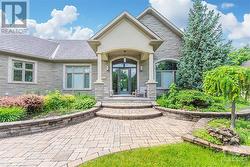 Gracious front entrance complete with an interlock walkway, covered front porch complemented by perennial gardens. - 