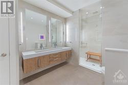 Lower level spa-like bathroom, floating vanity, tiled walk-in shower complete with double rain head shower & built in storage niches. - 