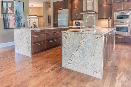 Dual islands feature granite countertops with vein-matched waterfall sides, providing ample prep space for the whole family to help out. - 6163 Pebblewoods Drive, Ottawa, ON - Indoor Photo Showing Kitchen With Upgraded Kitchen