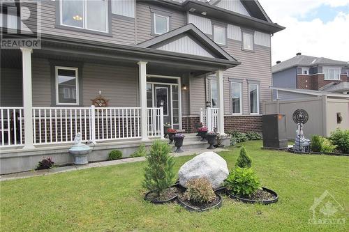 The exterior is beautifully landscaped, creating welcoming curb appeal.  Relax on the large covered verandah, ideal for enjoying sunny afternoons. - 273 Enclave Walk, Ottawa, ON - Outdoor With Deck Patio Veranda