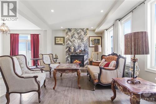 Open-concept main living area which boasts a natural gas fireplace with an elegant mantle and large, sun filled windows. - 273 Enclave Walk, Ottawa, ON - Indoor With Fireplace