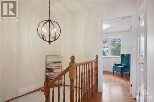 The bright stairway with its hardwood floor features an elegant chandelier. - 4405 Ashcroft Circle, Ottawa, ON - Indoor Photo Showing Other Room