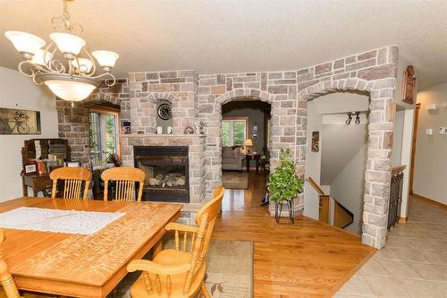 85 Heritage Drive, Dufferin, MB - Indoor Photo Showing Dining Room With Fireplace