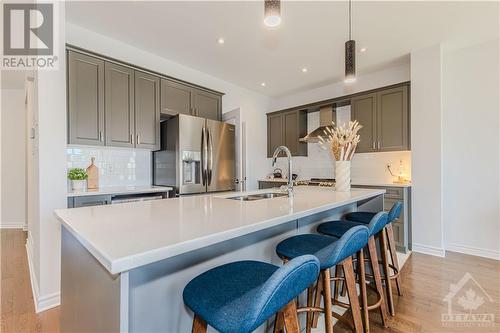 White, sleek center island with breakfast bar - 600 Triangle Street, Ottawa, ON - Indoor Photo Showing Kitchen With Double Sink With Upgraded Kitchen