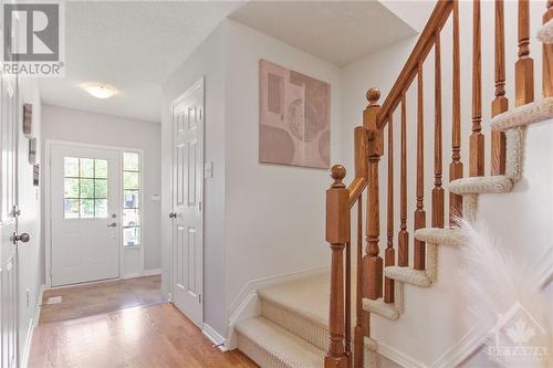 Main floor with curved staircase and hardwood & tile flooring. - 210 Rolling Meadow Crescent, Ottawa, ON 