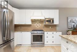 Beautiful kitchen features modern appliances including a gas stove, and granite countertops. - 
