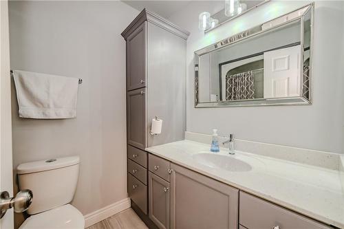 Main bath has ample storage and solid surface counter top with integral sink - 61 Richmond Crescent, Stoney Creek, ON - Indoor Photo Showing Bathroom