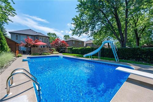 The slide and diving board offer even more fun ways to get wet - 61 Richmond Crescent, Stoney Creek, ON - Outdoor With In Ground Pool With Backyard