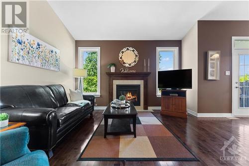 Living room with gas fireplace and tons of natural light flooding in from the private backyard overlooking the field backing onto the property. - 470 Landswood Way, Ottawa, ON - Indoor Photo Showing Living Room With Fireplace
