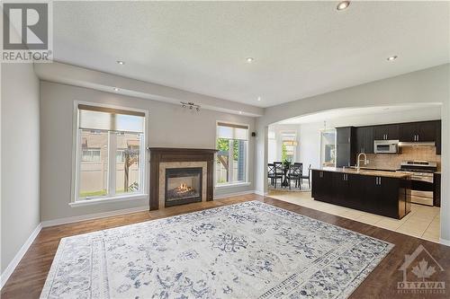 Family room with gleaming hardwood floors and gas burning fireplace - 284 Calaveras Avenue, Ottawa, ON - Indoor Photo Showing Living Room With Fireplace