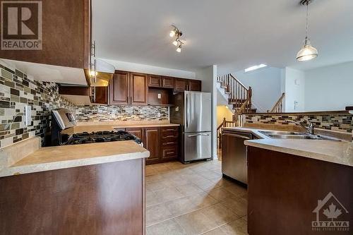 The beautiful open-concept kitchen features a great kitchen island with plenty of counter and cupboard space, stainless steel appliances, and real wood cabinets. - 972 Linaria Walk, Ottawa, ON - Indoor Photo Showing Kitchen With Double Sink