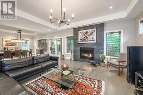 big windows looking over trees  gardens - 1 - 570 Windermere Road, London, ON - Indoor Photo Showing Living Room With Fireplace