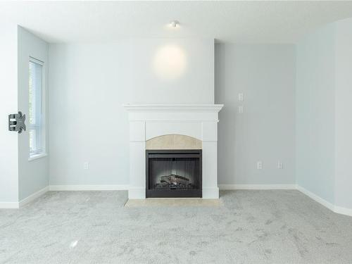 207-5660 Edgewater Lane, Nanaimo, BC - Indoor Photo Showing Living Room With Fireplace