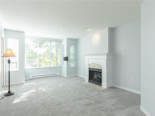 207-5660 Edgewater Lane, Nanaimo, BC - Indoor Photo Showing Living Room With Fireplace