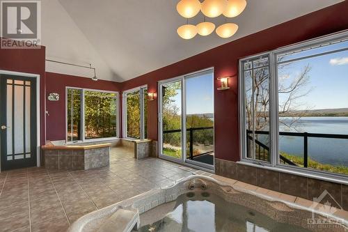 Spa area with hot tub overlooking the river, two sided fireplace shared with Family Room, Rain shower, sauna and 2piece bath. - 325 Berry Side Road, Kanata, ON -  Photo Showing Other Room With Body Of Water