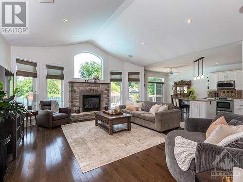 Livingroom with vaulted ceilings,beautiful stone gas fireplace, wired in speakers & lots of windows create a very warm and inviting room. - 50 Frances Colbert Avenue, Ottawa, ON - Indoor Photo Showing Living Room With Fireplace