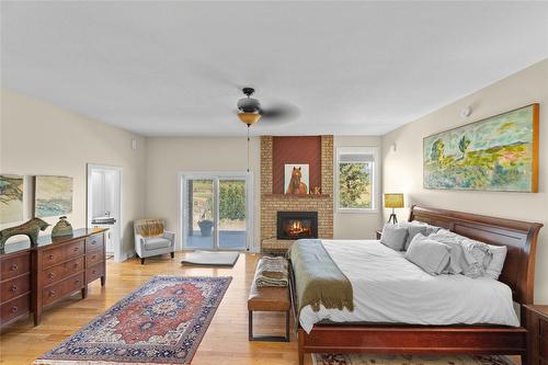 1258 Round Lake Road, Spallumcheen, BC - Indoor Photo Showing Bedroom With Fireplace