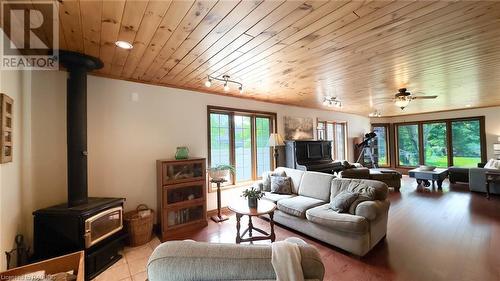 Family room with woodstove and custom wood beam open staircase. - 46 Bell Drive, Huron-Kinloss, ON - Indoor Photo Showing Living Room