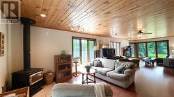 Family room with woodstove and custom wood beam open staircase. - 