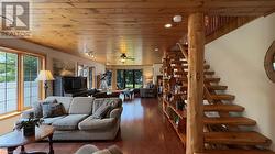 Family room with woodstove and custom wood beam open staircase. - 