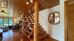 Family room with woodstove and custom wood beam open staircase. - 