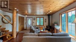 Family room with woodstove and custom wood beam open staircase. - 