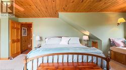 Primary bedroom with dormer window, sitting area and balcony overlooking the lake. - 