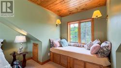 Primary bedroom with dormer window, sitting area and balcony overlooking the lake. - 