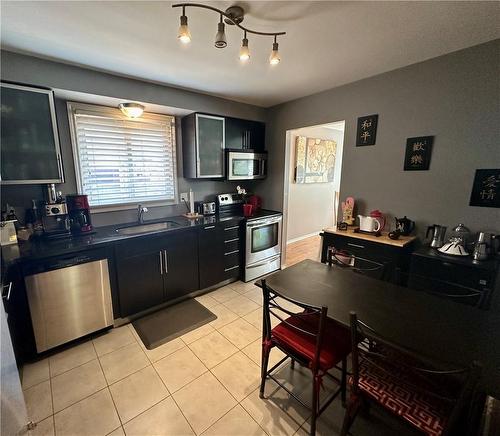 Main floor eat-in Kitchen w/black granite counter tops, SS appliances, and pullout pantry cupboard - 16 Flamingo Drive, Hamilton, ON - Indoor