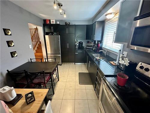 Main floor eat-in Kitchen w/black granite counter tops, SS appliances, and pullout pantry cupboard - 16 Flamingo Drive, Hamilton, ON - Indoor