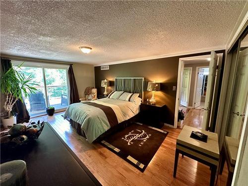 Master bedroom with a walkout to a large deck overlooking the tranquil backyard - 16 Flamingo Drive, Hamilton, ON - Indoor Photo Showing Bedroom