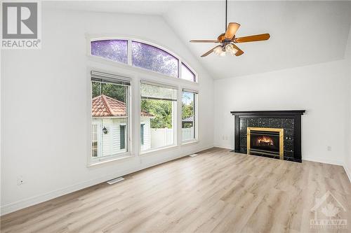 Family room with marble gas fireplace and wall of windows to enjoy the view of the backyard.. - 34 Stonemeadow Drive, Ottawa, ON - Indoor Photo Showing Living Room With Fireplace