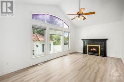 Family room with marble gas fireplace and wall of windows to enjoy the view of the backyard.. - 