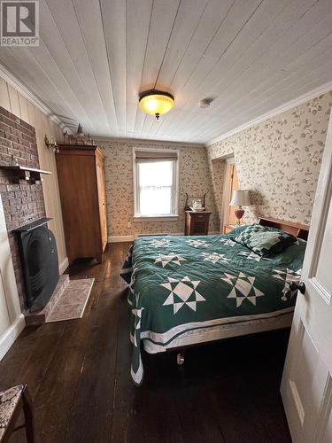 4 Dandy Lane, Trinity, NL - Indoor Photo Showing Bedroom With Fireplace