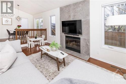 Unwind in the sunken family room by the cozy wood fireplace. - 1454 Shawinigan Street, Ottawa, ON - Indoor Photo Showing Living Room With Fireplace