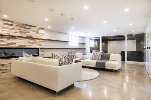 Basement Level Offers Beautiful Heated, Polished Concrete Floors. Deep, Bright Windows Give A Feeling Of Being On The Main Level. - 147 Mountain Park Avenue, Hamilton, ON - Indoor Photo Showing Living Room With Fireplace