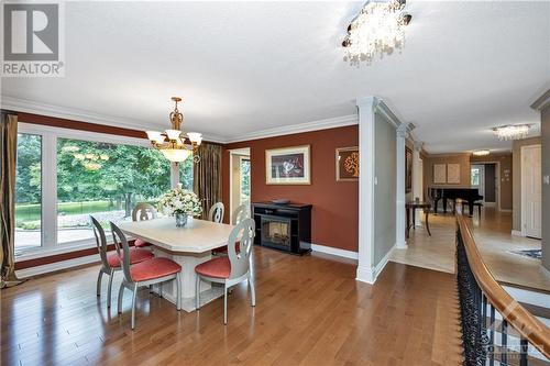 Dining room open to kitchen, just inside front door and steps to the stairs to the lower level. - 105 Locharron Crescent, Ottawa, ON - Indoor Photo Showing Dining Room With Fireplace