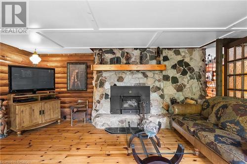 The picture of comfort. All the logs, flooring and wood details in this home were crafted from trees on the property. - 579 Cape Hurd Road, Tobermory, ON - Indoor Photo Showing Other Room With Fireplace