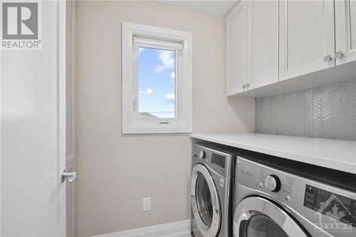 Second floor laundry with custom cabinets and backsplash - 4530 Kelly Farm Drive, Ottawa, ON - Indoor Photo Showing Laundry Room