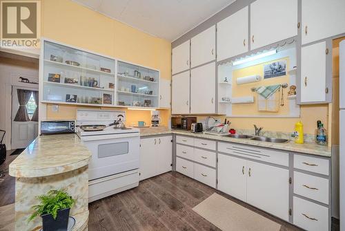 Open storage for display pieces. Front door entrance on LT. - 29 Bonnechere Street E, Eganville, ON - Indoor Photo Showing Kitchen With Double Sink