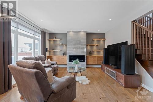 Living Room with large windows and stone fireplace/floating shelving - 1870 Maple Grove Road, Ottawa, ON - Indoor With Fireplace